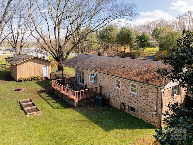 back of house with a lawn, a wooden deck, a storage shed, and cooling unit