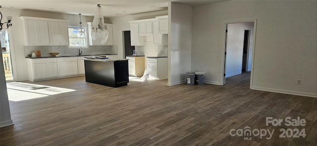 kitchen with white cabinets, dark hardwood / wood-style flooring, a kitchen island, and hanging light fixtures