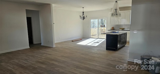 kitchen featuring tasteful backsplash, a center island, dark hardwood / wood-style floors, white cabinetry, and hanging light fixtures