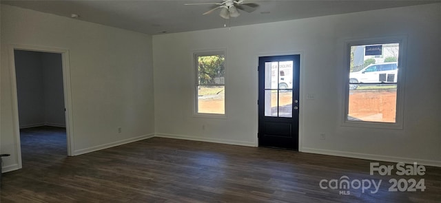 spare room with ceiling fan, plenty of natural light, and dark wood-type flooring