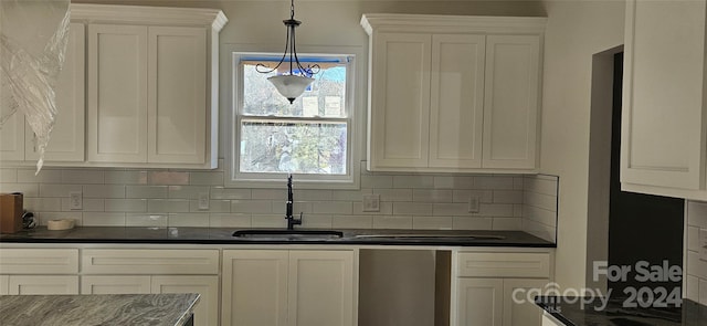 kitchen featuring white cabinets, pendant lighting, tasteful backsplash, and sink