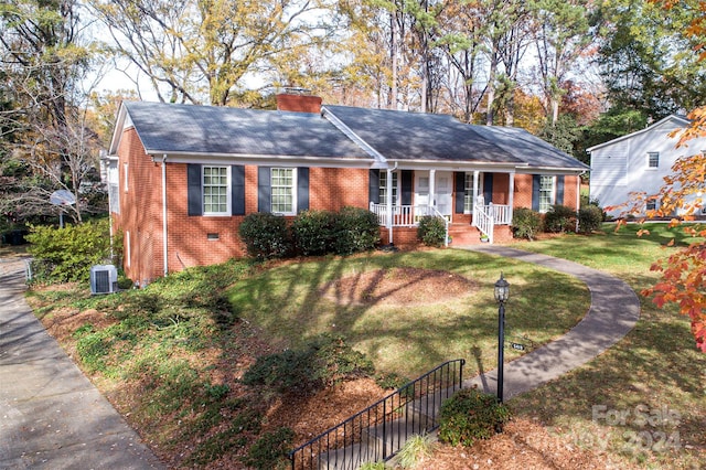 single story home with cooling unit, covered porch, and a front yard