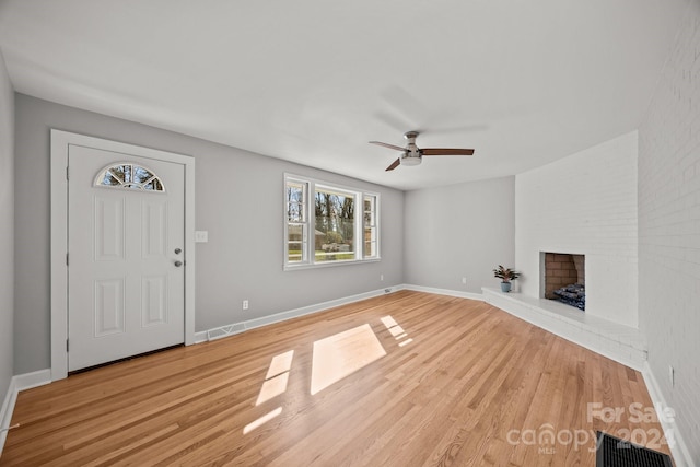 unfurnished living room with a fireplace, light hardwood / wood-style floors, and ceiling fan