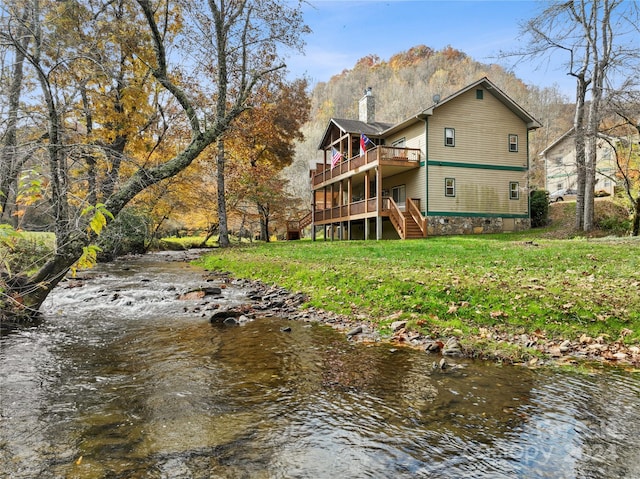 back of property with a deck with water view