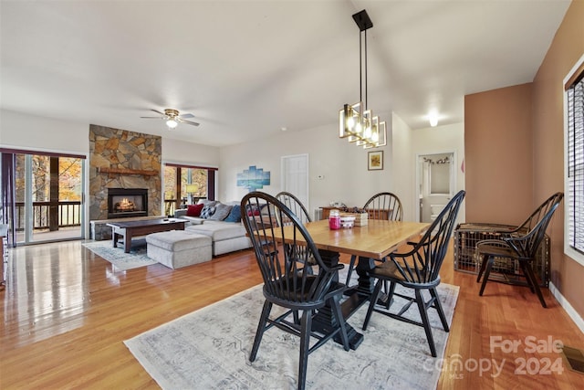 688 Olympic Dr Unit 2, Whittier, NC 28789 - dining space with light wood-type flooring, ceiling fan, and a stone fireplace