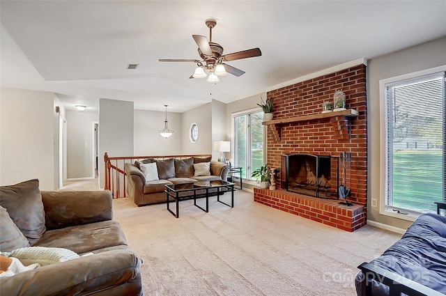 carpeted living room with a brick fireplace, ceiling fan, and a wealth of natural light