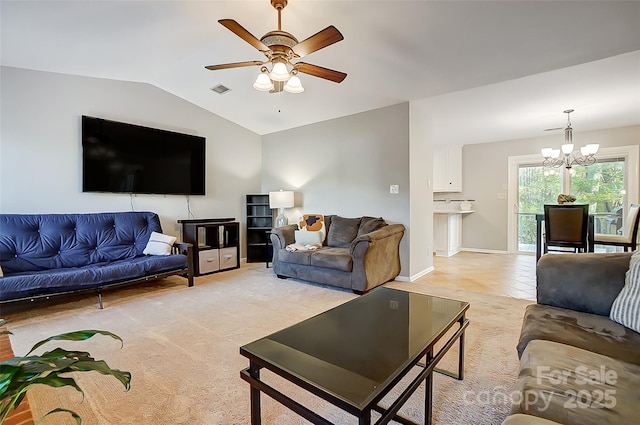 carpeted living room featuring lofted ceiling and ceiling fan with notable chandelier