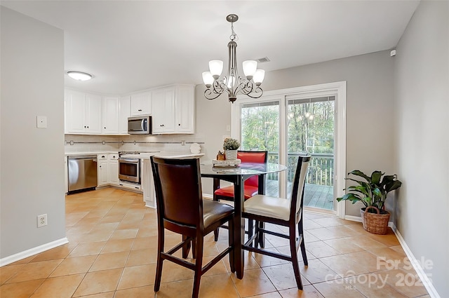 dining area with light tile patterned flooring and a chandelier