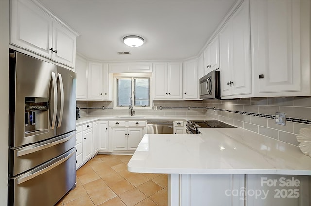 kitchen featuring appliances with stainless steel finishes, white cabinets, kitchen peninsula, and light tile patterned floors