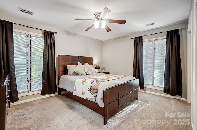 carpeted bedroom featuring ceiling fan and multiple windows