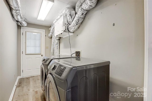 laundry room featuring light hardwood / wood-style floors and washing machine and clothes dryer