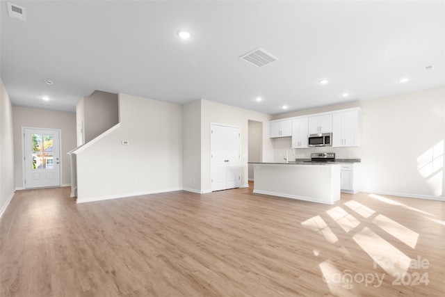 unfurnished living room featuring light hardwood / wood-style floors and sink