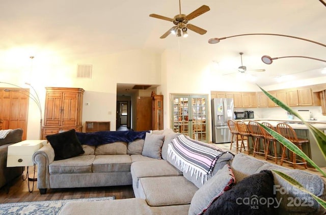 living room featuring ceiling fan, dark hardwood / wood-style flooring, and high vaulted ceiling