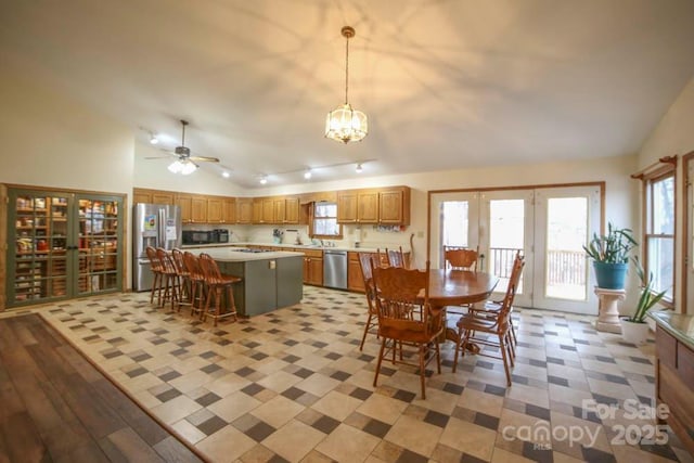 dining area featuring lofted ceiling, ceiling fan with notable chandelier, and french doors