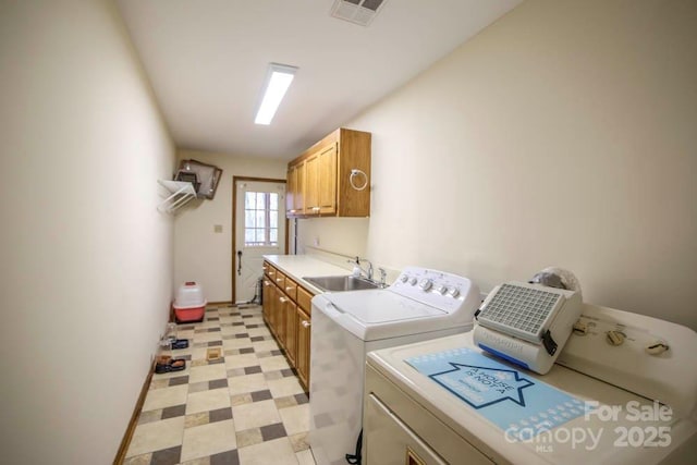 washroom featuring washer and dryer, cabinets, and sink