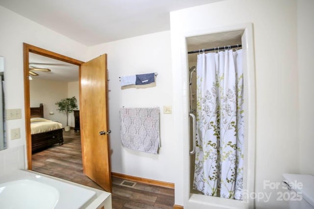 bathroom featuring toilet, a shower with shower curtain, and ceiling fan