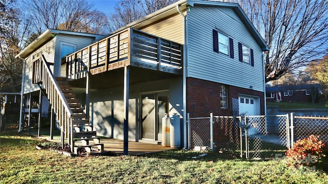 rear view of property with a yard, a deck, and a garage