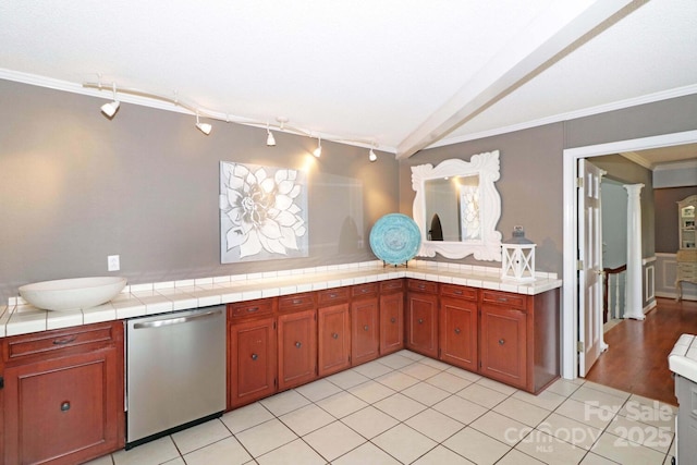 kitchen featuring rail lighting, ornamental molding, stainless steel dishwasher, tile counters, and light tile patterned floors