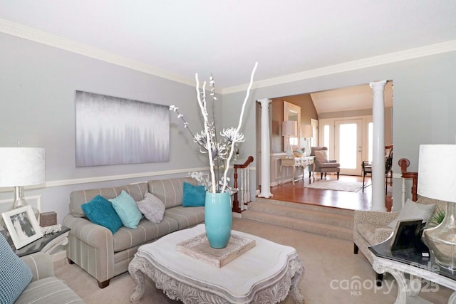 carpeted living room with decorative columns, vaulted ceiling, and crown molding