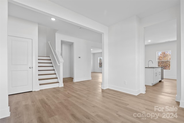 183 Sugar Hill Rd, Troutman, NC 28166 - unfurnished living room with stairway, light wood-type flooring, baseboards, a sink, and recessed lighting