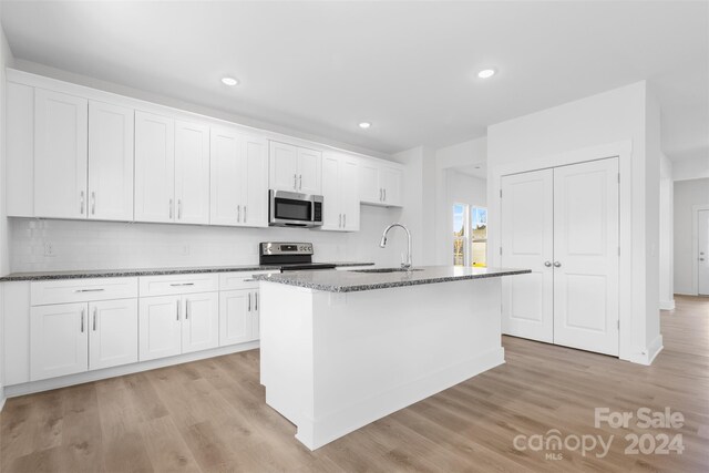 183 Sugar Hill Rd, Troutman, NC 28166 - kitchen featuring appliances with stainless steel finishes, a sink, dark stone countertops, white cabinetry, and backsplash