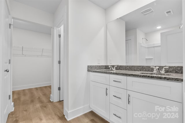 183 Sugar Hill Rd, Troutman, NC 28166 - bathroom with double vanity, wood finished floors, baseboards, and a spacious closet