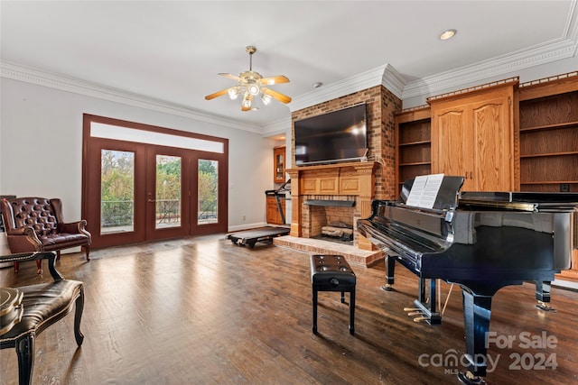 misc room featuring ornamental molding, ceiling fan, hardwood / wood-style floors, a fireplace, and french doors