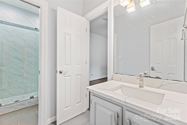 bathroom with vanity, tile patterned flooring, and a shower with door