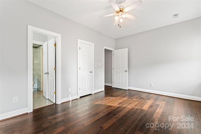 unfurnished bedroom featuring dark wood-type flooring, ceiling fan, and connected bathroom