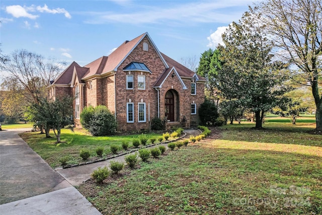 english style home with a front lawn