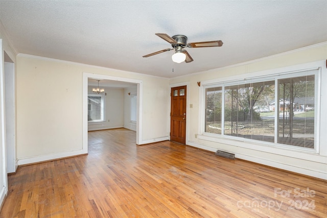 unfurnished room with ceiling fan with notable chandelier, crown molding, light wood-type flooring, and a textured ceiling