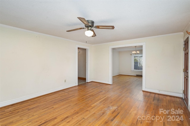 unfurnished room featuring a textured ceiling, ceiling fan with notable chandelier, light hardwood / wood-style floors, and crown molding