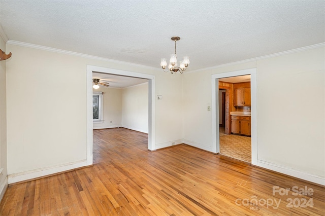 spare room with crown molding, ceiling fan with notable chandelier, a textured ceiling, and hardwood / wood-style flooring