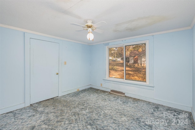 spare room with a textured ceiling, carpet floors, ceiling fan, and ornamental molding