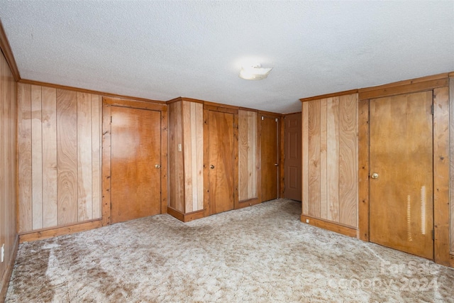 interior space featuring a textured ceiling and wooden walls