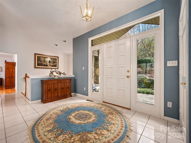 foyer with lofted ceiling with beams, light tile patterned floors, and a notable chandelier