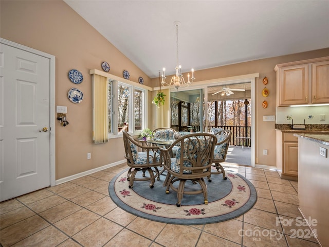 tiled dining area with ceiling fan with notable chandelier, a wealth of natural light, and vaulted ceiling