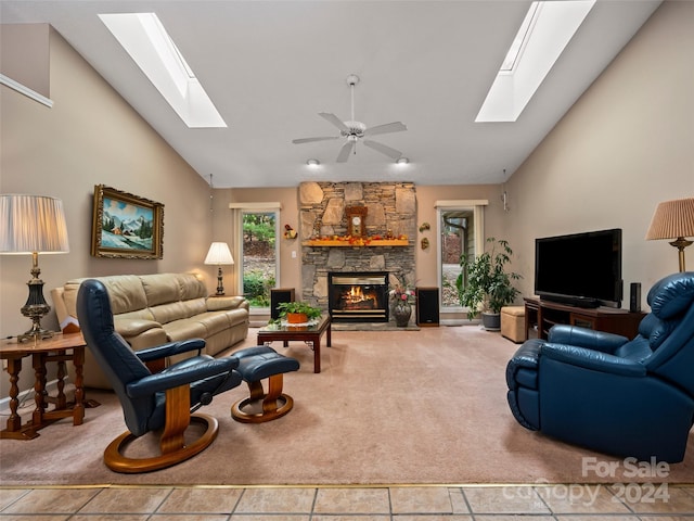 living room with a stone fireplace, tile patterned flooring, and a wealth of natural light