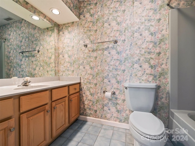 bathroom featuring tile patterned flooring, vanity, a tub to relax in, and toilet