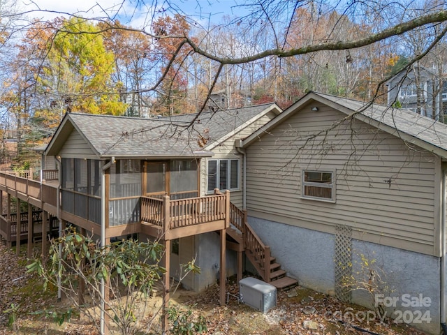 back of house with a sunroom and a wooden deck