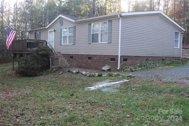 view of side of home featuring a deck and a yard