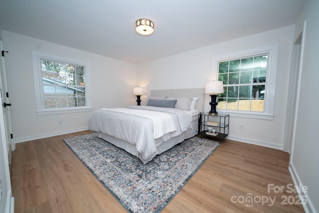 bedroom featuring multiple windows and hardwood / wood-style floors