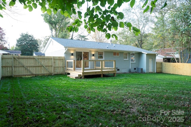 back of house featuring a wooden deck, central air condition unit, and a lawn