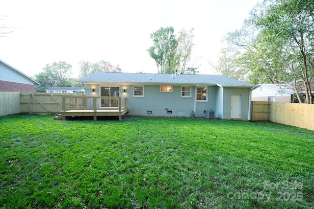 rear view of property with a lawn, a wooden deck, and central AC unit