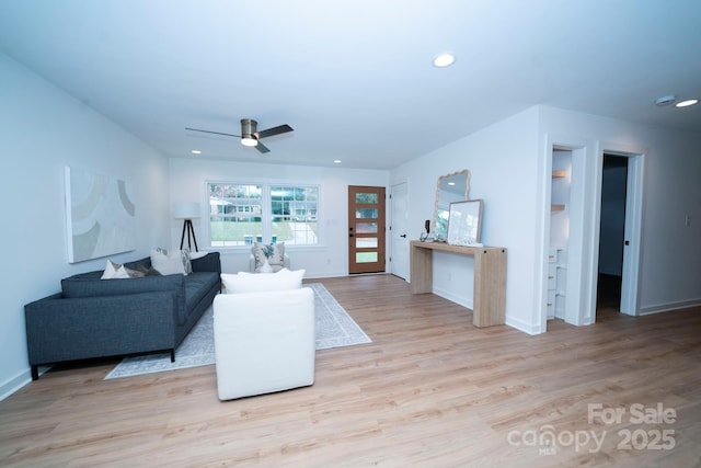 living room featuring ceiling fan and light hardwood / wood-style flooring