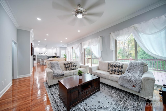 living room featuring ceiling fan, light wood-type flooring, and ornamental molding