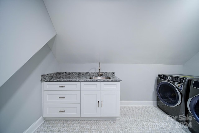 washroom with cabinets, independent washer and dryer, and sink