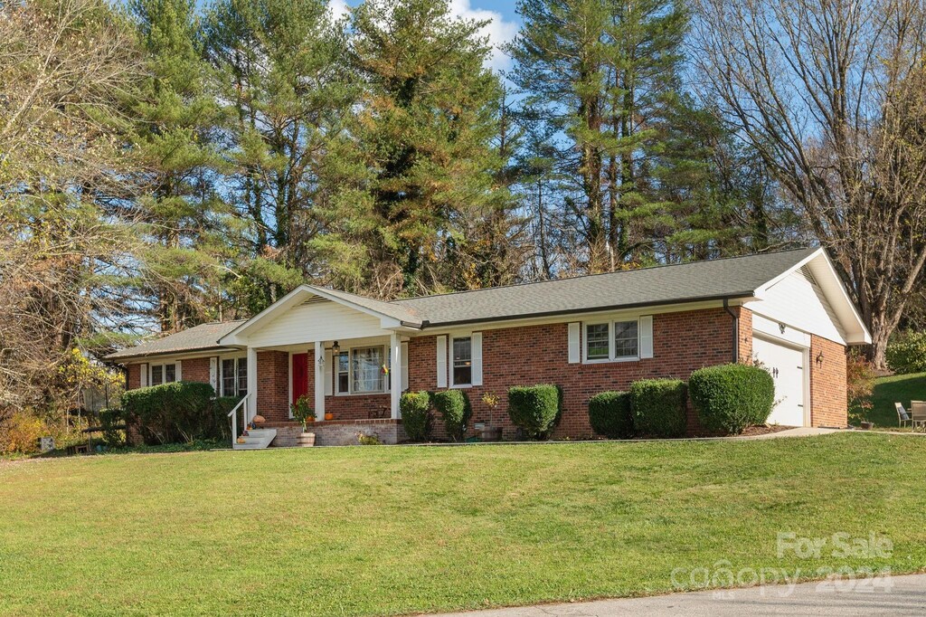 ranch-style home with a garage and a front lawn