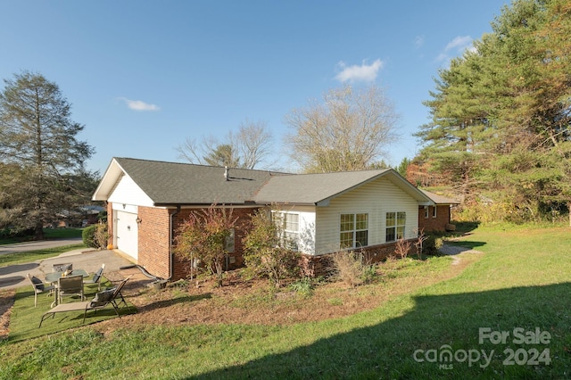 view of side of property featuring a garage and a lawn