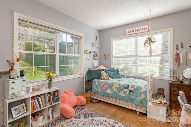 bedroom with hardwood / wood-style flooring and a textured ceiling